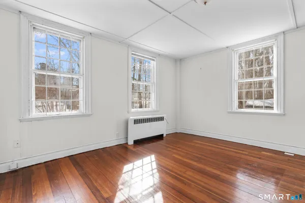 a view of a room with wooden floor and windows