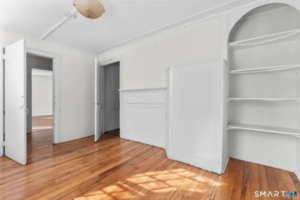 a view of empty room with wooden floor