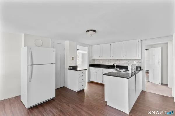 a kitchen with white cabinets and white appliances