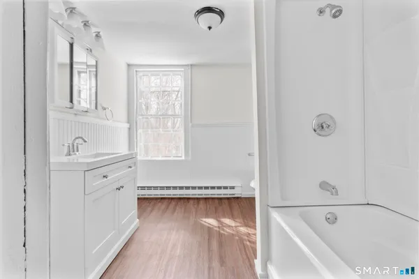 a bathroom with a tub sink and mirror