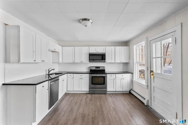 a kitchen with granite countertop white cabinets and white appliances