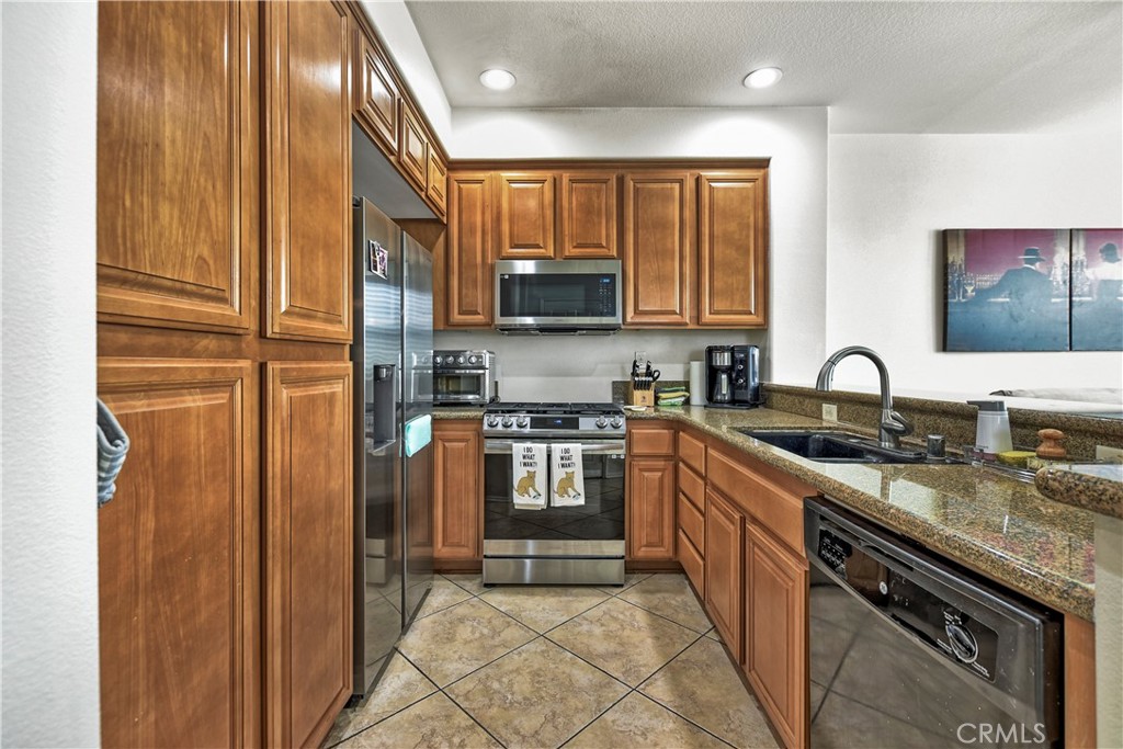 3894 Polk Street, Unit E Riverside, CA 92505 - Photo 8 of 28 a kitchen with stainless steel appliances granite countertop a stove a sink and a microwave
