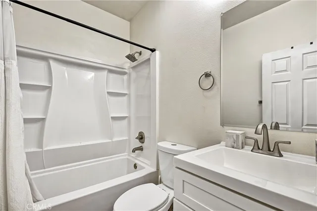 a bathroom with a sink toilet vanity and shower