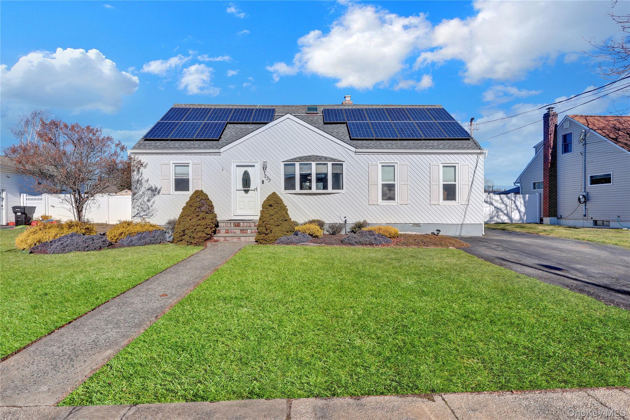 a front view of a house with a garden and yard