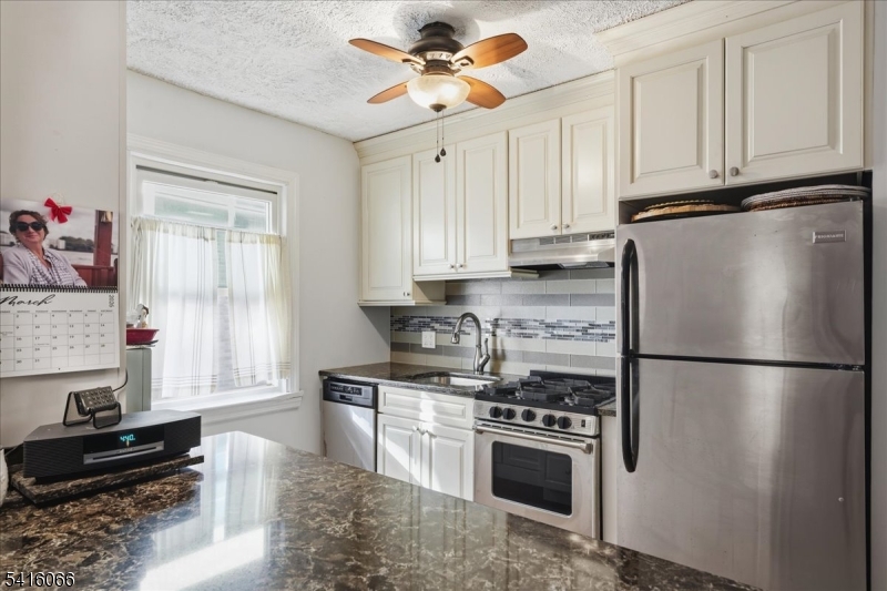 a kitchen with stainless steel appliances granite countertop a refrigerator stove top oven and sink