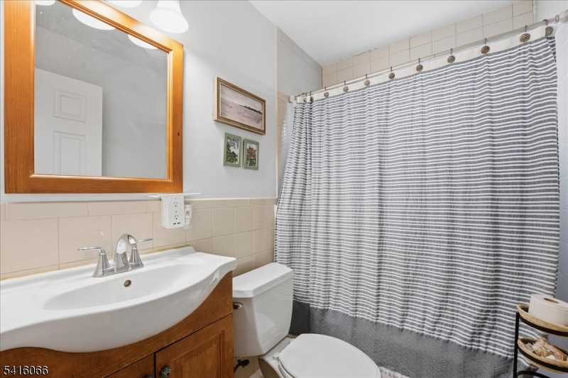 753 Broad Avenue, Unit A Ridgefield, NJ 07657 - Photo 16 of 23 a bathroom with a sink a toilet and mirror