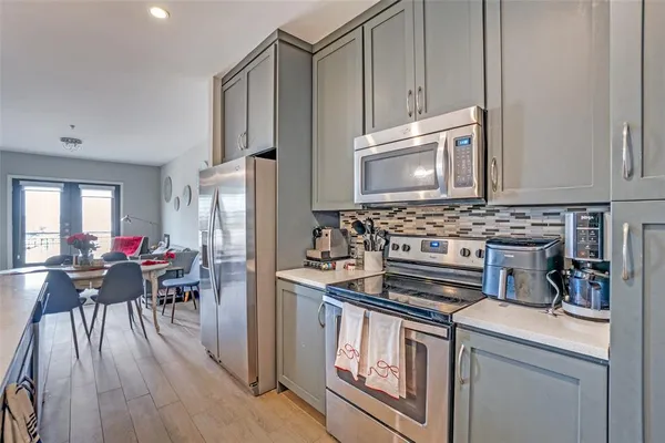 a kitchen with appliances cabinets and wooden floor