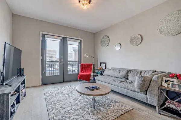 a living room with furniture a flat screen tv and a window