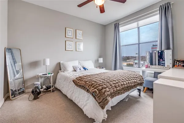 a bedroom with a bed a chandelier and a large window