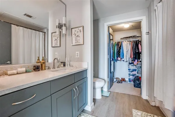 a en suite bathroom with a granite countertop sink mirror vanity and toilet
