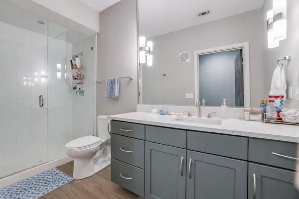 a bathroom with a double vanity sink toilet and a mirror