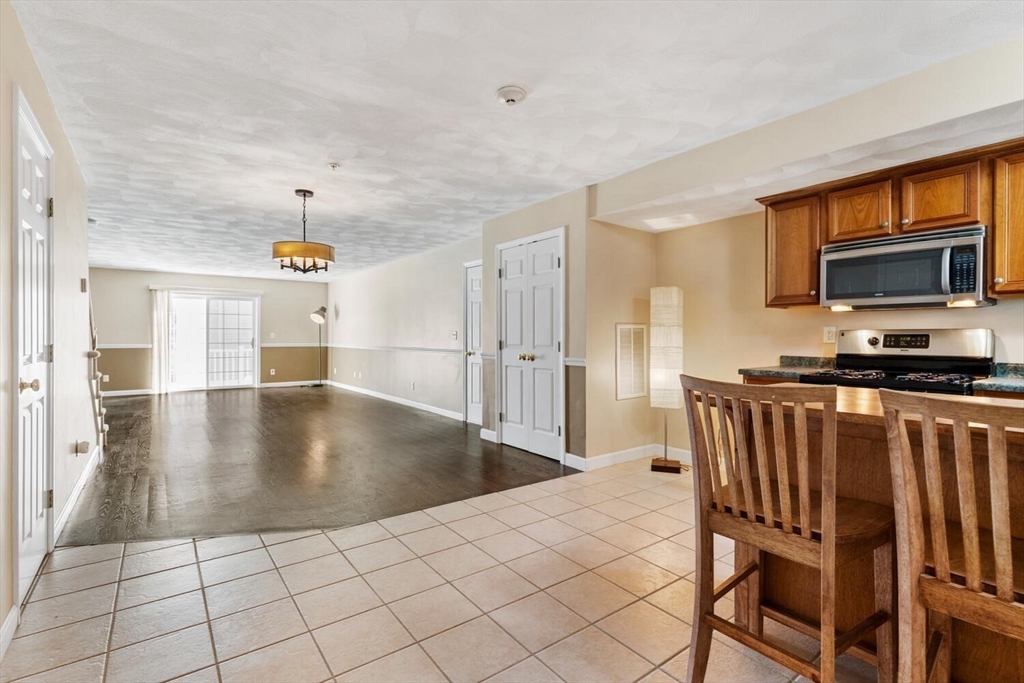 18 Dale Street, Unit 9D Andover, MA 01810 - Photo 11 of 33 a kitchen with stainless steel appliances a dining table chairs and granite counter tops
