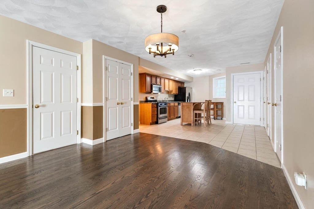 18 Dale Street, Unit 9D Andover, MA 01810 - Photo 13 of 33 a view of a dining room with furniture a chandelier and wooden floor