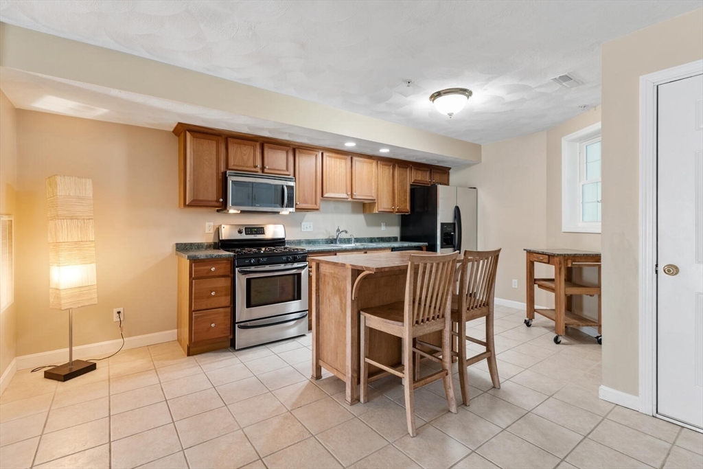 18 Dale Street, Unit 9D Andover, MA 01810 - Photo 6 of 33 a kitchen with granite countertop a stove a sink and a refrigerator