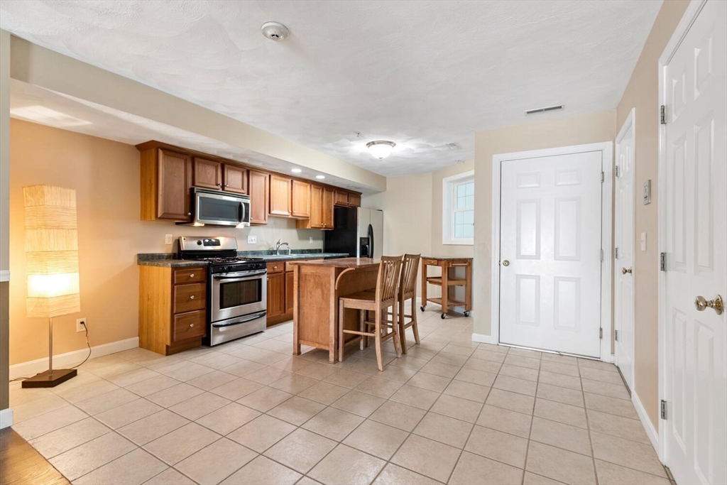 18 Dale Street, Unit 9D Andover, MA 01810 - Photo 7 of 33 a dining area with stainless steel appliances a refrigerator and a stove top oven