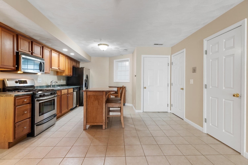 18 Dale Street, Unit 9D Andover, MA 01810 - Photo 9 of 33 a kitchen with stainless steel appliances granite countertop a stove top oven a sink dishwasher and a refrigerator