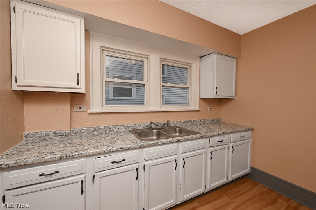 77 West Mildred Avenue Akron, OH 44310 - Photo 15 of 40 Kitchen with white cabinetry, light wood finished floors, and light stone counters