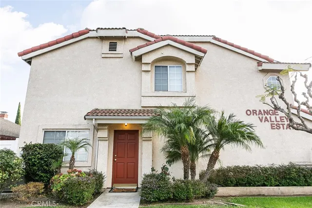 a front view of a house with a yard and potted plants