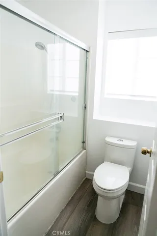 a white toilet sitting next to a bath tub
