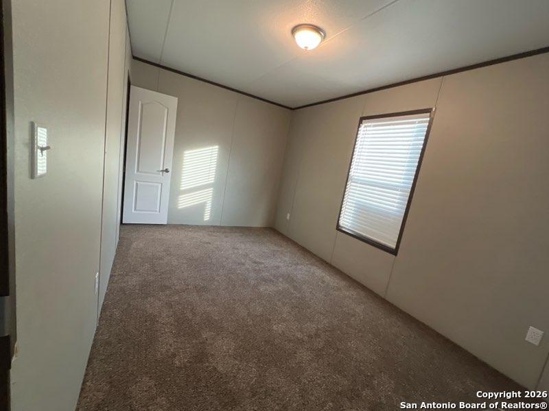 1029 Bowen Street Pleasanton, TX 78064 - Photo 3 of 4 an empty room with windows