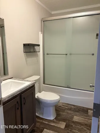 a bathroom with a granite countertop sink toilet and a mirror