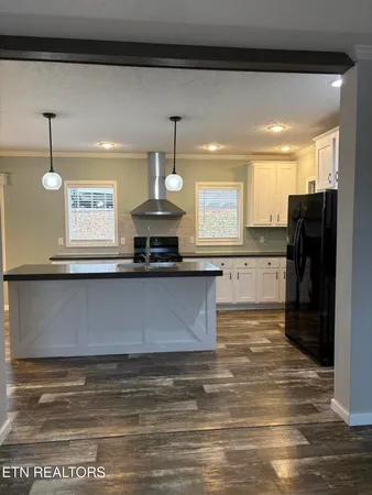 a view of a kitchen center island wooden floor and a window
