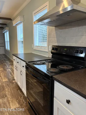 a kitchen with granite countertop a stove and a sink