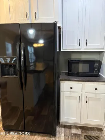 a kitchen with granite countertop white cabinets and stainless steel appliances