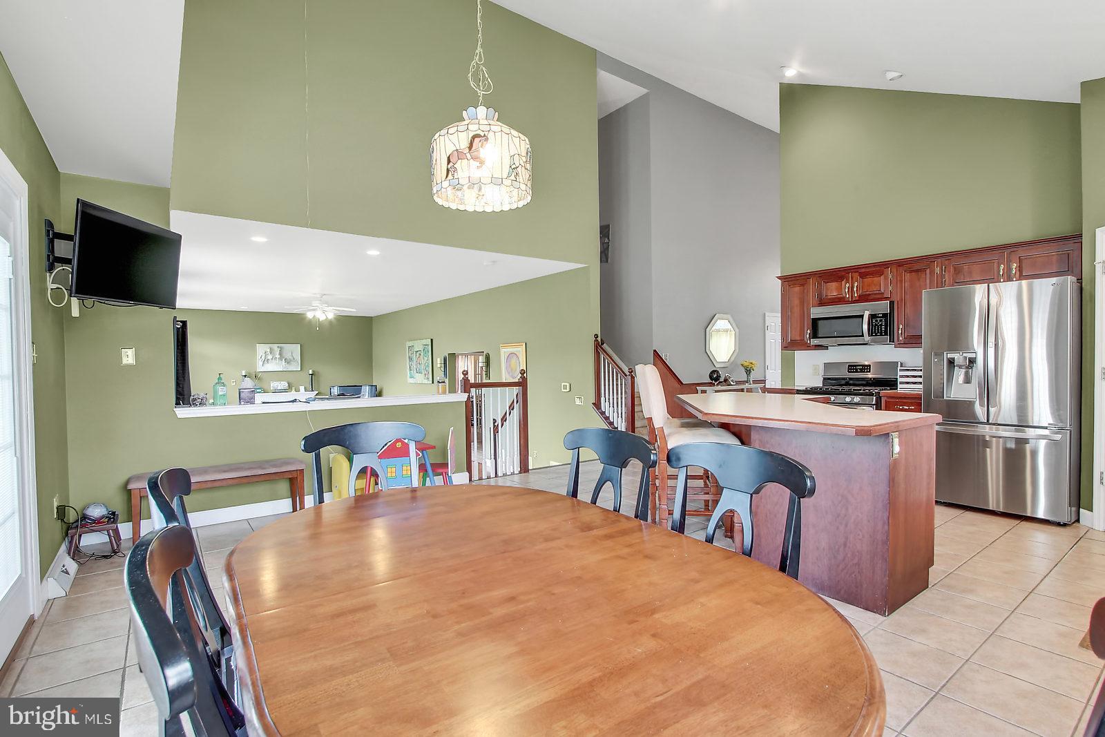 109 Atlantic Avenue Sinking Spring, PA 19608 - Photo 9 of 25 a kitchen with stainless steel appliances kitchen island granite countertop a dining table chairs and a refrigerator