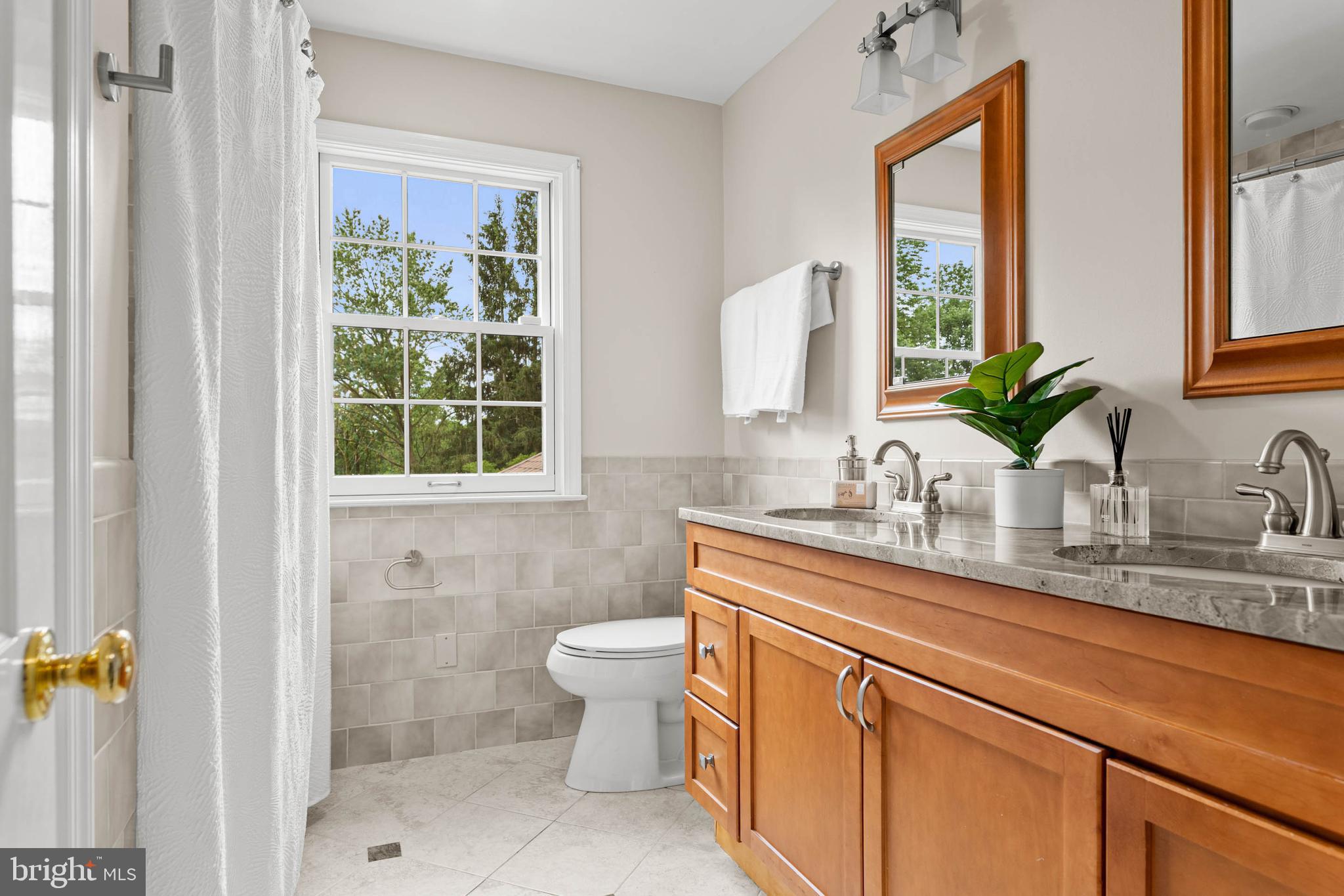 240 Church Road Devon, PA 19333 - Photo 46 of 75 a bathroom with a granite countertop sink a toilet and mirror