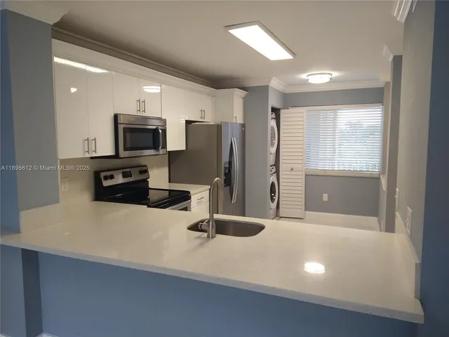 a kitchen with stainless steel appliances a refrigerator sink and stove