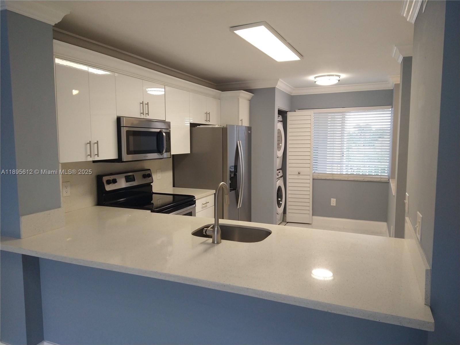 a kitchen with stainless steel appliances a refrigerator sink and stove