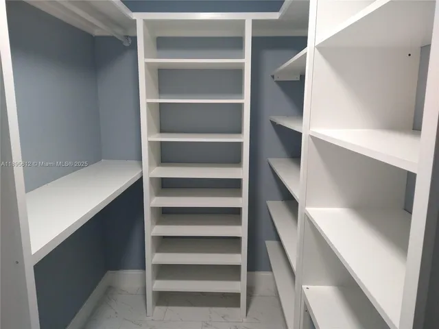 a view of walk in closet with empty racks