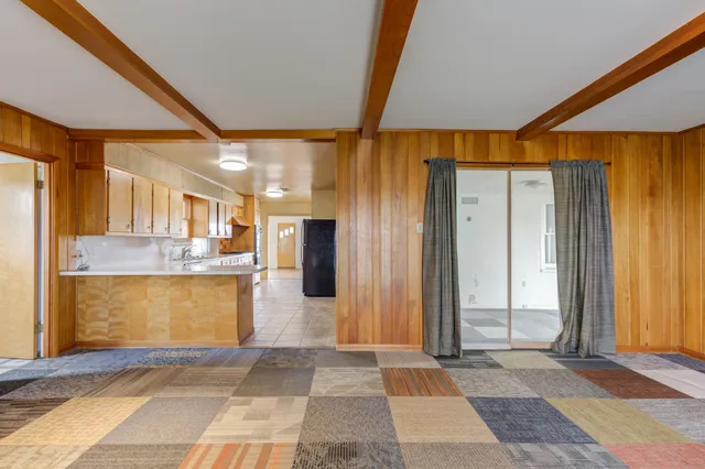 a view of a hallway with a dining table and chairs