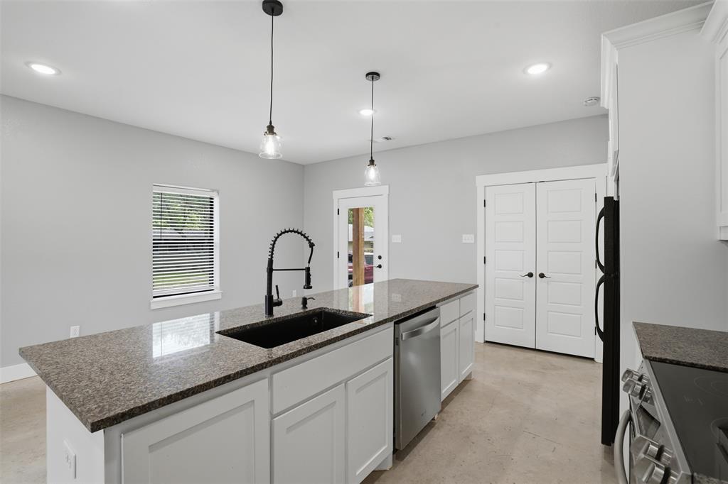 738 East Sears Street Denison, TX 75021 - Photo 14 of 32 a kitchen with kitchen island a sink appliances and a counter top space