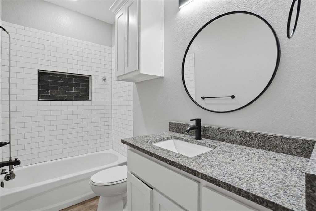 738 East Sears Street Denison, TX 75021 - Photo 25 of 32 a bathroom with a sink a toilet and a mirror