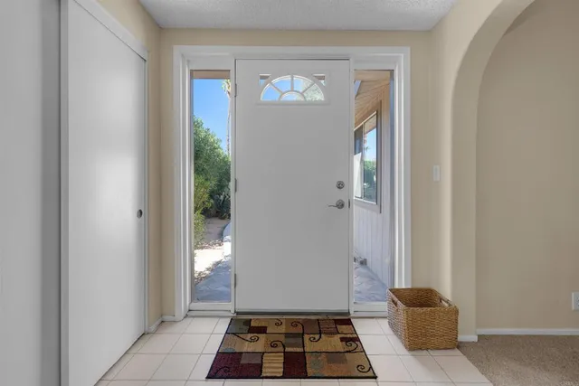a view of a hallway with wooden floor and a living room