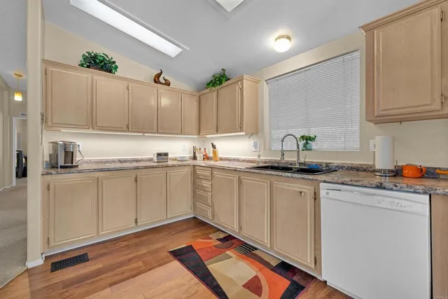 a kitchen with granite countertop white cabinets and white appliances