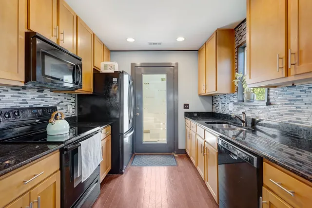 a kitchen with stainless steel appliances granite countertop a stove a sink and a microwave
