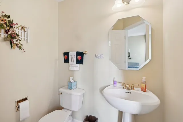 a bathroom with a toilet sink and mirror