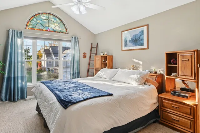 a bedroom with a large bed a chandelier and dresser