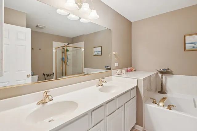 a bathroom with a sink a tub and a mirror