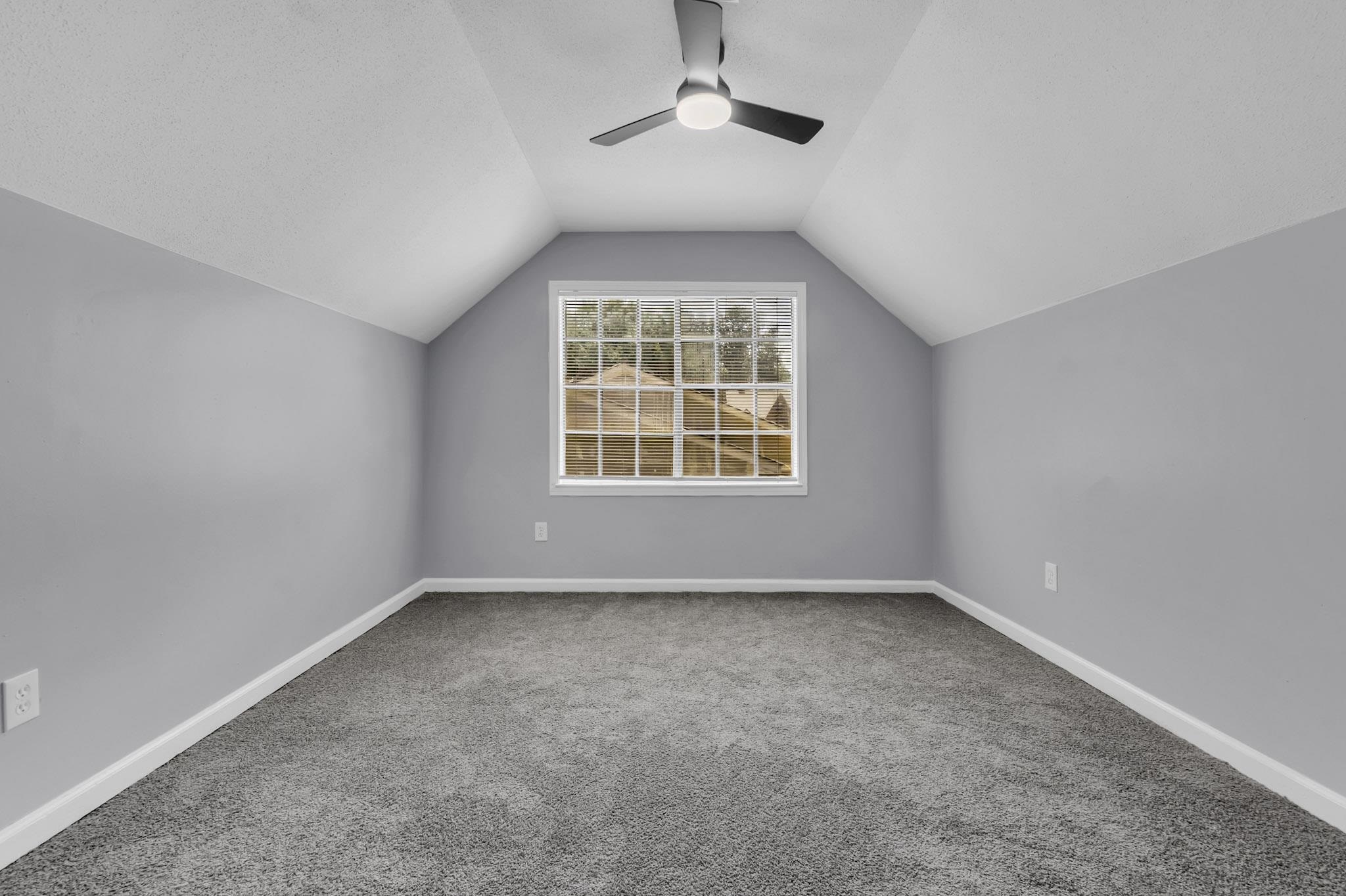 3314 Bright Ridge Cove Memphis, TN 38115 - Photo 14 of 16 Vaulted ceiling room featuring a central window, ceiling fan, plush grey carpet, and light grey wall finishes with white trim