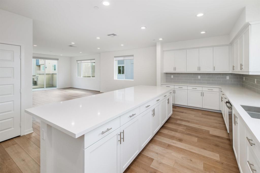 6140 Colt Place, Unit 104 Carlsbad, CA 92009 - Photo 11 of 37 a large white kitchen with cabinets