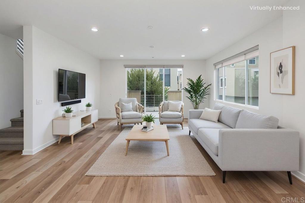 6140 Colt Place, Unit 104 Carlsbad, CA 92009 - Photo 3 of 37 a living room with furniture wooden floor and a flat screen tv