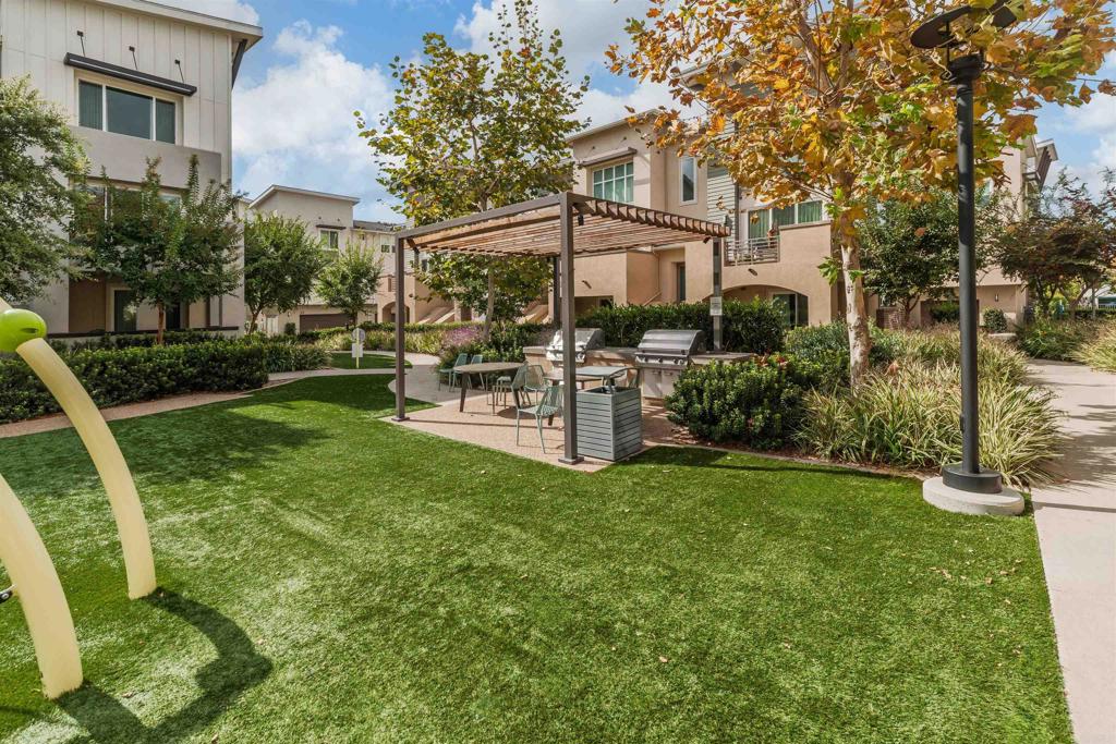 6140 Colt Place, Unit 104 Carlsbad, CA 92009 - Photo 33 of 37 a view of a patio with table and chairs and potted plants