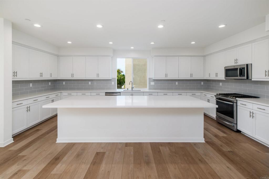 6140 Colt Place, Unit 104 Carlsbad, CA 92009 - Photo 10 of 37 a kitchen with granite countertop white cabinets and white appliances
