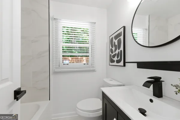 a bathroom with a sink a toilet and a mirror