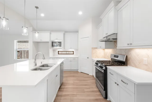 a kitchen with stainless steel appliances granite countertop a sink stove and refrigerator