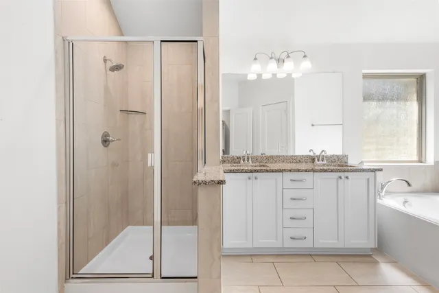 a bathroom with a granite countertop sink a mirror and a bathtub